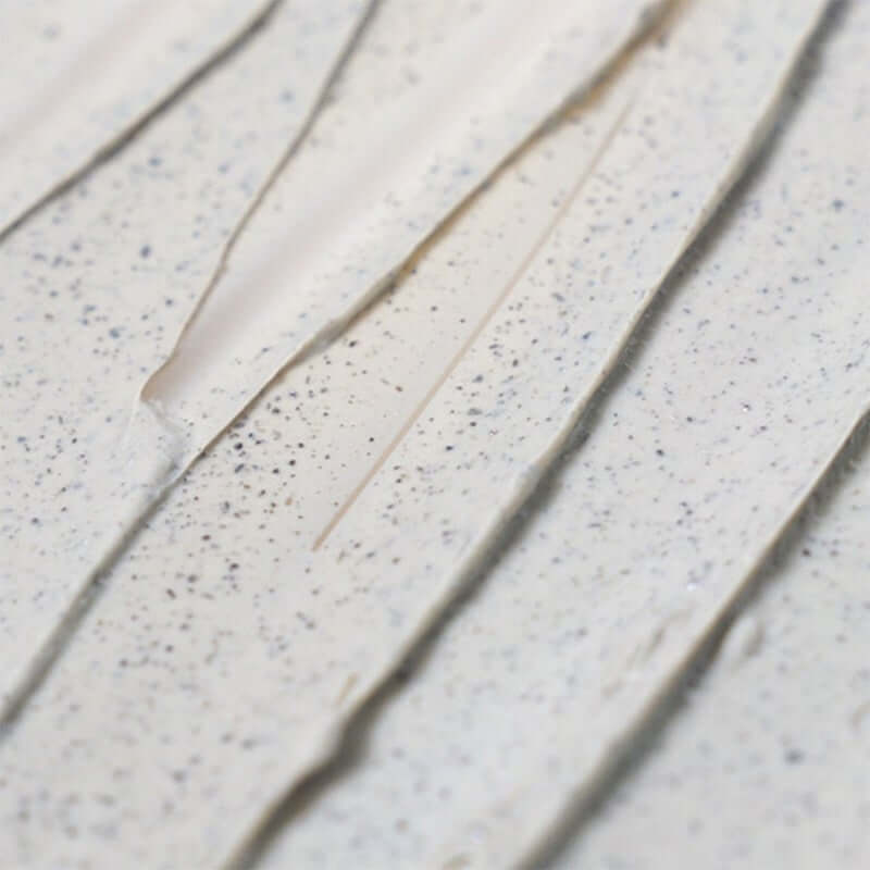 Close-up of Isntree Mugwort Calming Clay Face Mask showing its smooth texture and granular red bead powder.